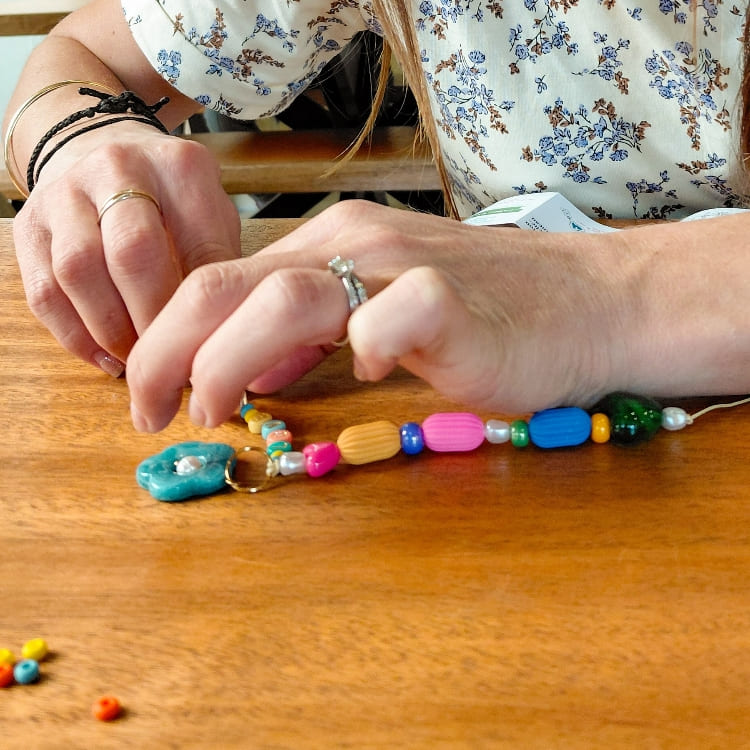 création grigri à la main avec perles colorées